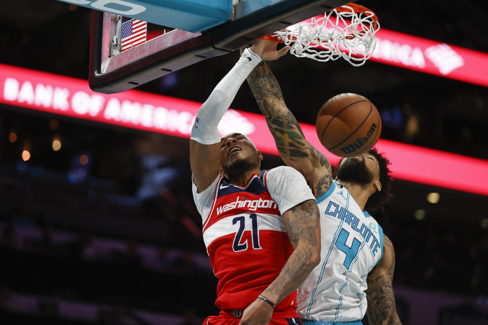 Washington Wizards center Daniel Gafford, left, dunks against Charlotte Hornets center Nick Richards during the first half of an NBA basketball game in Charlotte, N.C., Friday, Dec. 2, 2022. (AP Photo/Nell Redmond)