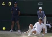 Milos Raonic of Canada falls during his men's singles semi-final tennis match against Roger Federer of Switzerland at the Wimbledon Tennis Championships, in London July 4, 2014. REUTERS/Suzanne Plunkett (BRITAIN - Tags: SPORT TENNIS)