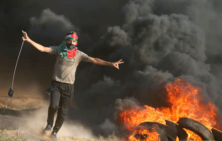 A Palestinian holds a sling to hurl stones at Israeli troops during a protest calling for lifting the Israeli blockade on Gaza and demand the right to return to their homeland, at the Israel-Gaza border fence, east of Gaza City September 14, 2018. REUTERS/Mohammed Salem