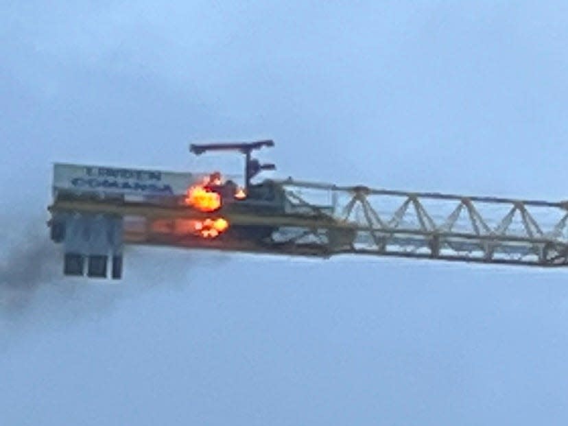 A fire burns atop a construction crane associated with new Harbor Bridge project on Saturday, April 22, 2023, in Corpus Christi, Texas.
