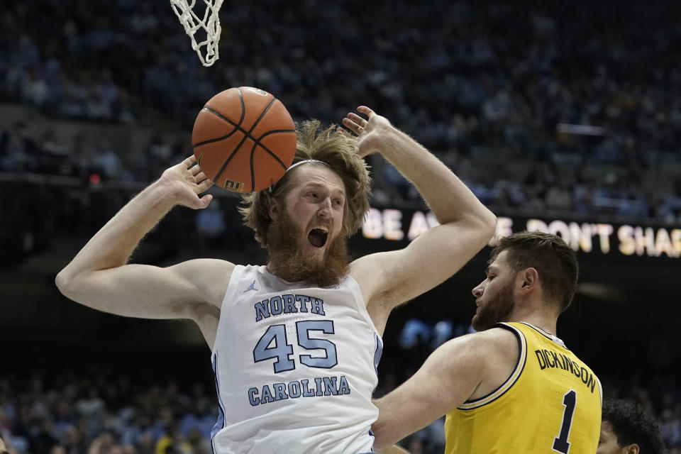 North Carolina forward Brady Manek (45) reacts following a dunk against Michigan center Hunter Dickinson (1) during the first half of an NCAA college basketball game in Chapel Hill, N.C., Wednesday, Dec. 1, 2021. (AP Photo/Gerry Broome)