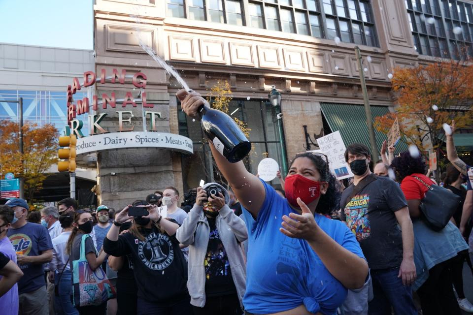 Raven Smith sprays the crowd in celebration outside the Pennsylvania Convention Center after Joe Biden was declared winner of the 2020 presidential election on Saturday in Philadelphia, Pennsylvania.