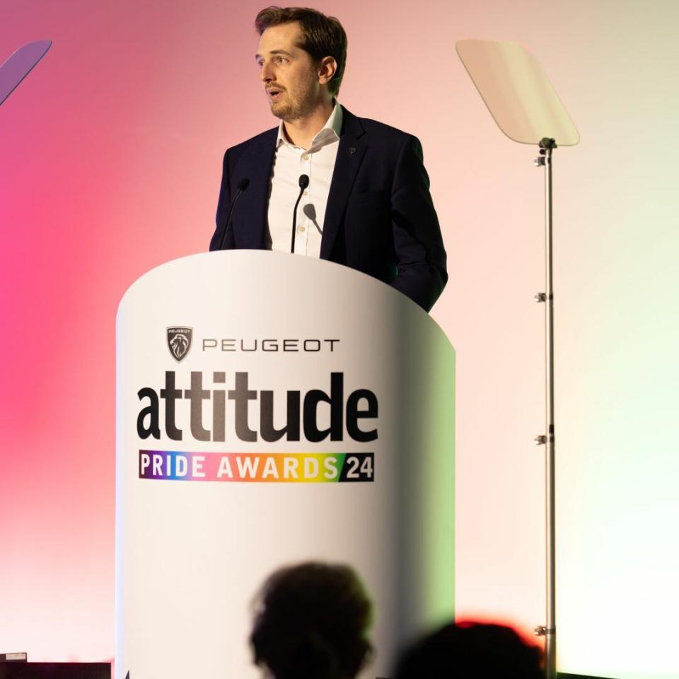 A man stands onstage delivering a speech