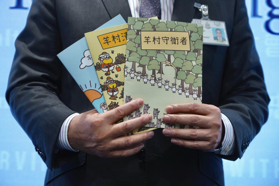Li Kwai-wah, senior superintendent of Police National Security Department, poses with evidence including three children's books on stories that revolve around a village of sheep which has to deal with wolves from a different village, before a press conference in Hong Kong Thursday, July 22, 2021. Hong Kong's national security police on Thursday arrested five people from a trade union of the General Association of Hong Kong Speech Therapists on suspicion of conspiring to publish and distribute seditious material, in the latest arrests made amid a crackdown on dissent in the city.(AP Photo/Vincent Yu)