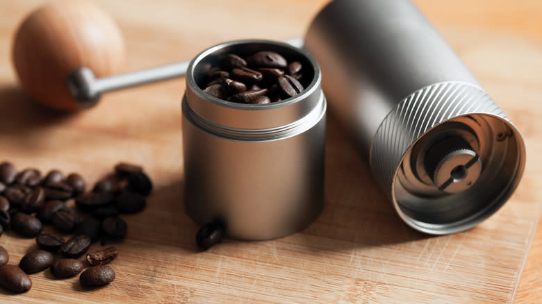 dark coffee beans in burr grinder