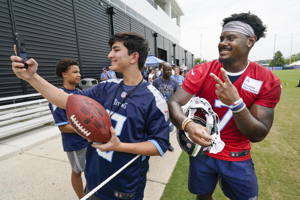 Tennessee Titans quarterback Malik Willis (7) poses for a photo with fan Seth Peak after a training camp practice at the NFL football team's facility Saturday, July 30, 2022, in Nashville, Tenn. (AP Photo/Mark Humphrey)