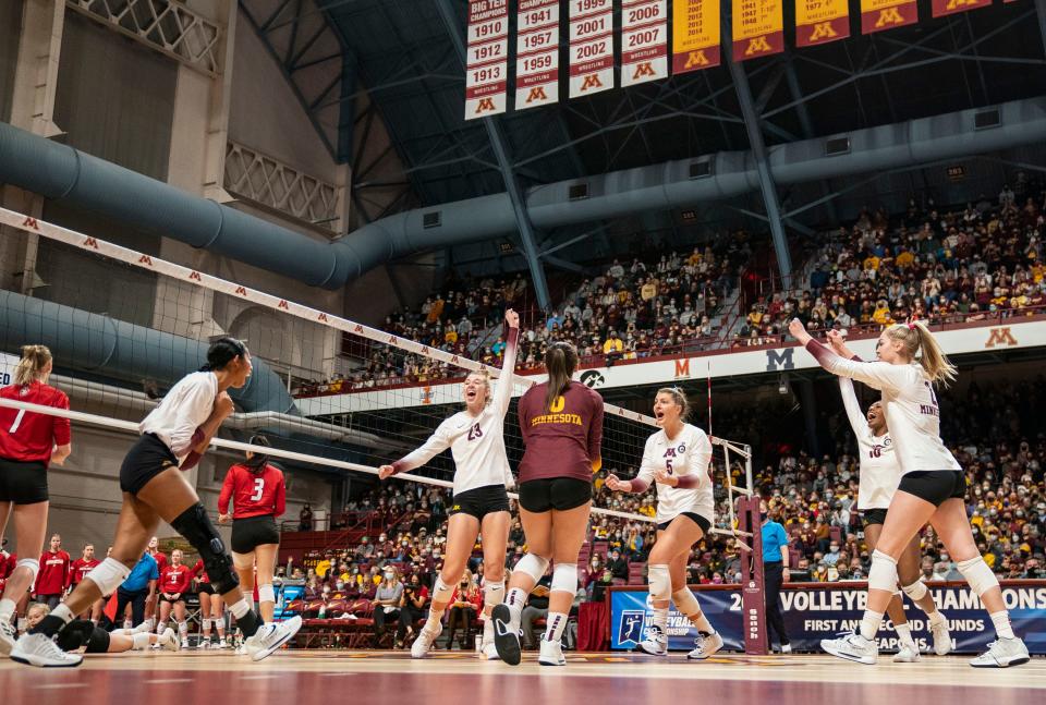 Minnesota players celebrate a point in the first set against South Dakota during a first-round match of the NCAA women's volleyball tournament, Friday, Dec. 3, 2021, in Minneapolis.