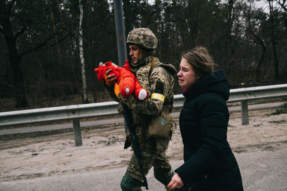 A Ukrainian soldier helps Julia Pavliuk and her daughter Emma evacuate the Kyiv suburb of Irpin, Ukraine, which Russian forces have tried to seize as part of their push to encircle the capital on March 5.<span class="copyright">Maxim Dondyuk</span>