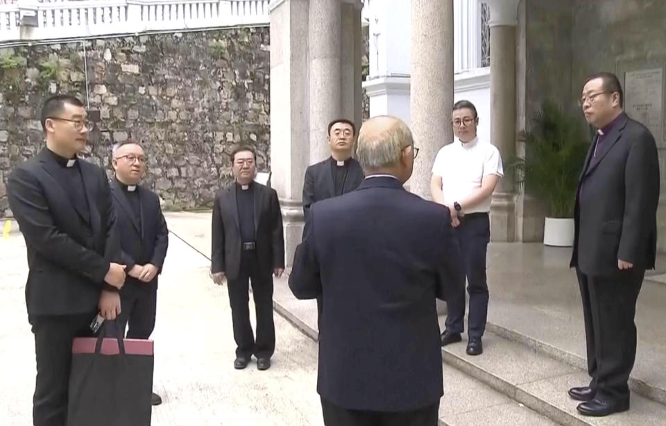 In this image taken from a video footage run by TVB, Joseph Li, the head of the Catholic church in China, right, stands outside Hong Kong's Cathedral of the Immaculate Conception in Hong Kong on Tuesday, Nov. 14, 2023. Li has arrived in Hong Kong at the invitation of the city's pope-appointed Roman Catholic cardinal, marking the first official visit by a Beijing bishop in history. (TVB via AP)