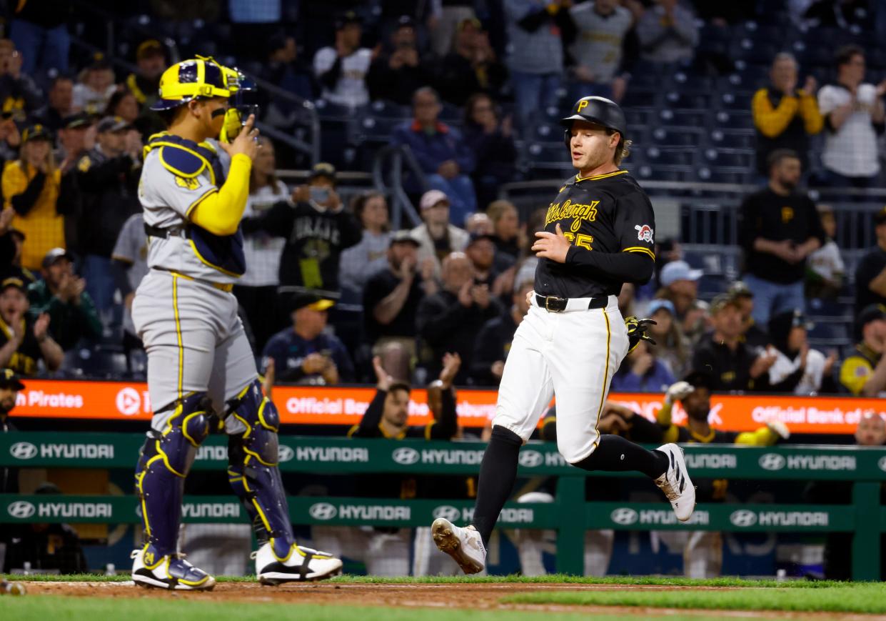 The Pirates' Jack Suwinski scores in front of Brewers catcher Carlos Contreras on a single in the sixth inning Monday night in Pittsburgh.