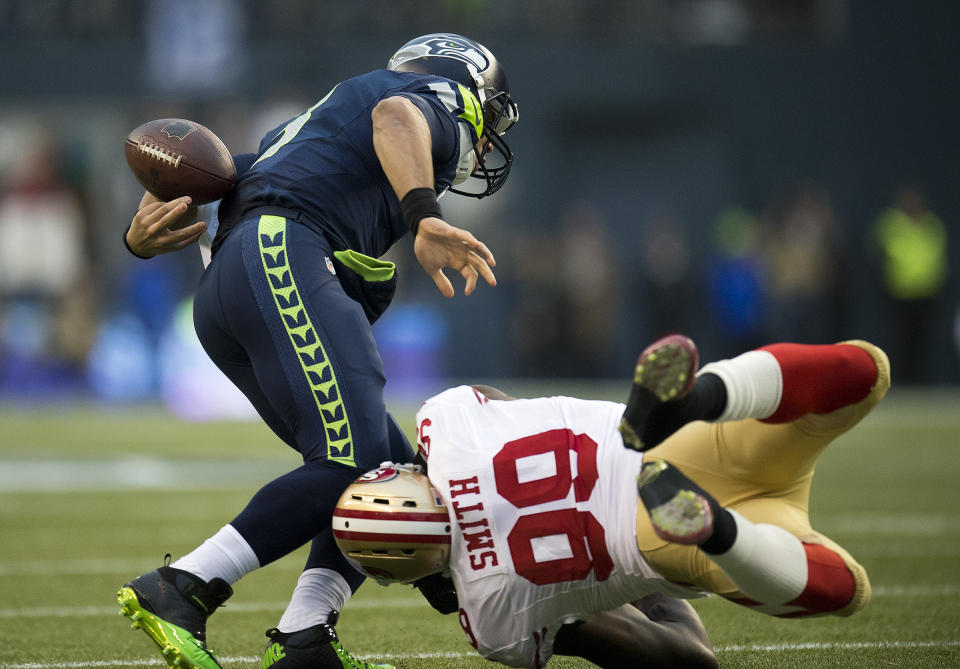 File-This Jan. 19, 2014, file photo shows San Francisco 49ers outside linebacker Aldon Smith (99) knocking the ball loose from Seattle Seahawks quarterback Russell Wilson (3) for a fumble recovered by the 49ers in the first quarter during the NFL football NFC Championship game in Seattle. As part of its celebration of its 100th season, the NFL is designating a Game of the Week, each chosen to highlight a classic matchup. For this week, it’s the 49ers-Seahawks game. To mark each Game of the Week, the AP will be reprinting its story of a classic matchup in the rivalry. This week it's the Seattle Seahawks' 23-17 win over the San Francisco 49ers in the NFC championship game on Jan. 19, 2014. (Paul Kitagaki Jr./The Sacramento Bee via AP, File)/The Sacramento Bee via AP)