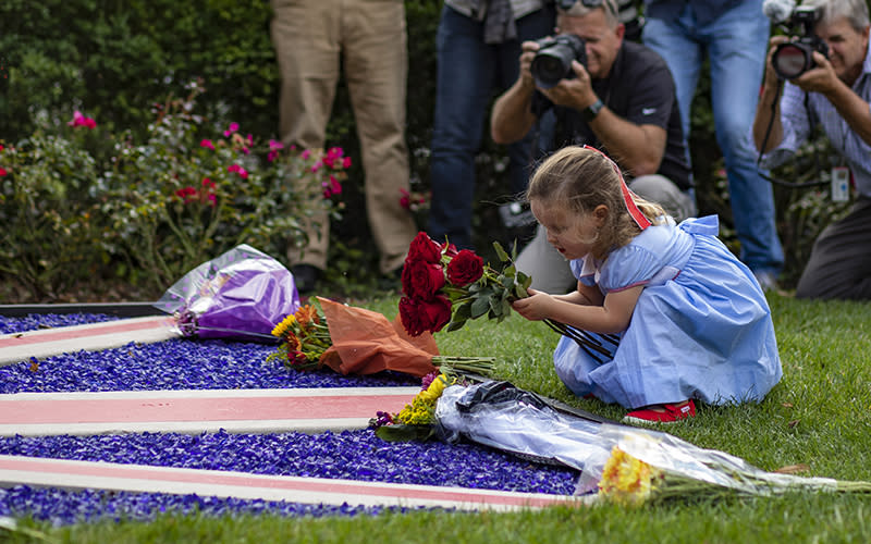 A child places flowers outside the British Embassy in Washington, D.C.