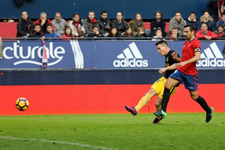 Atletico Madrid's forward Kevin Gameiro (L) vies with Osasuna's defender Miguel Fla–o and scores during the Spanish league football match CA Osasuna vs Club Atletico de Madrid on November 27, 2016