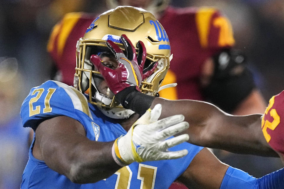 Southern California running back Darwin Barlow, right, fends off UCLA linebacker JonJon Vaughns during the second half of an NCAA college football game Saturday, Nov. 19, 2022, in Pasadena, Calif. (AP Photo/Mark J. Terrill)