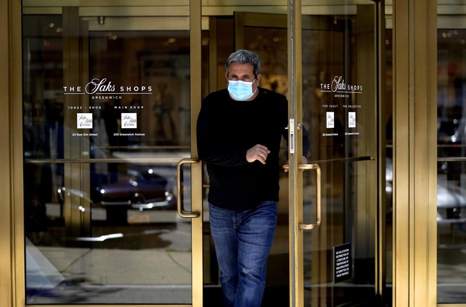 A man comes out of Saks Fifth Avenue on Greenwich Avenue in Greenwich, Connecticut on May 20, 2020 as Phase 1 of Reopening Connecticut begins today. - All 50 US states have now partially emerged from coronavirus lockdowns. Connecticut became the final state to begin lifting restrictions. (Photo by TIMOTHY A. CLARY / AFP) (Photo by TIMOTHY A. CLARY/AFP via Getty Images)