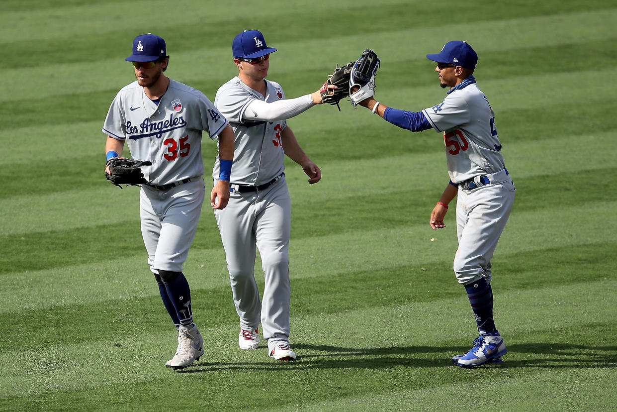 ANAHEIM, CALIFORNIA - AUGUST 16: Joc Pederson #31, Cody Bellinger #35 and Mookie Betts #50 of the Los Angeles Dodgers celebrate defeating the Los Angeles Angels 8-3 in a game at Angel Stadium of Anaheim on August 16, 2020 in Anaheim, California. (Photo by Sean M. Haffey/Getty Images)