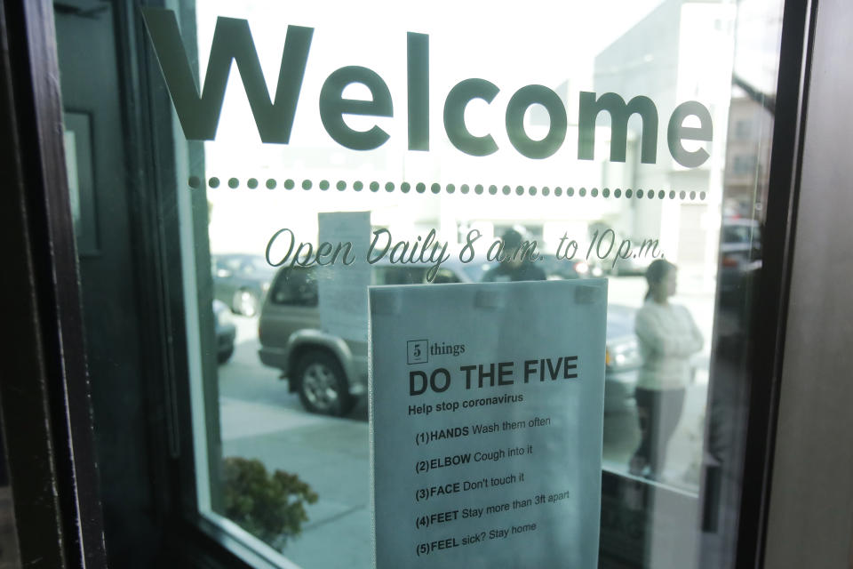 A sign about preventing the spread of the coronavirus is posted on the door of The Green Cross cannabis dispensary in San Francisco, Wednesday, March 18, 2020. As about 7 million people in the San Francisco Bay Area are under shelter-in-place orders, only allowed to leave their homes for crucial needs in an attempt to slow virus spread, marijuana stores remain open and are being considered "essential services." (AP Photo/Jeff Chiu)