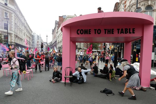 People participate in a protest of Extinction Rebellion climate activists next to a big model table, in central London, August 23, 2021 (Photo: Peter Nicholls via Reuters)