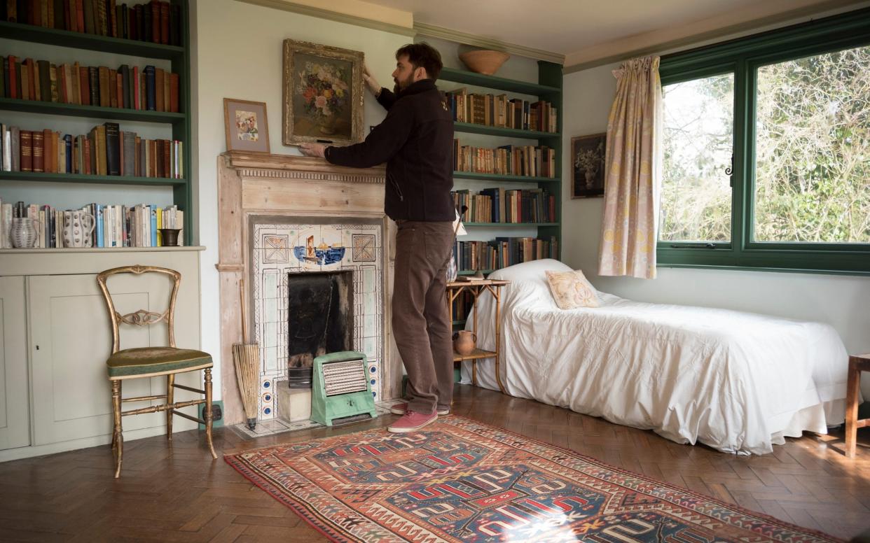 A National Trust employee hangs a picture in Virginia Woolf's bedroom at Monk's House - Christopher Pledger