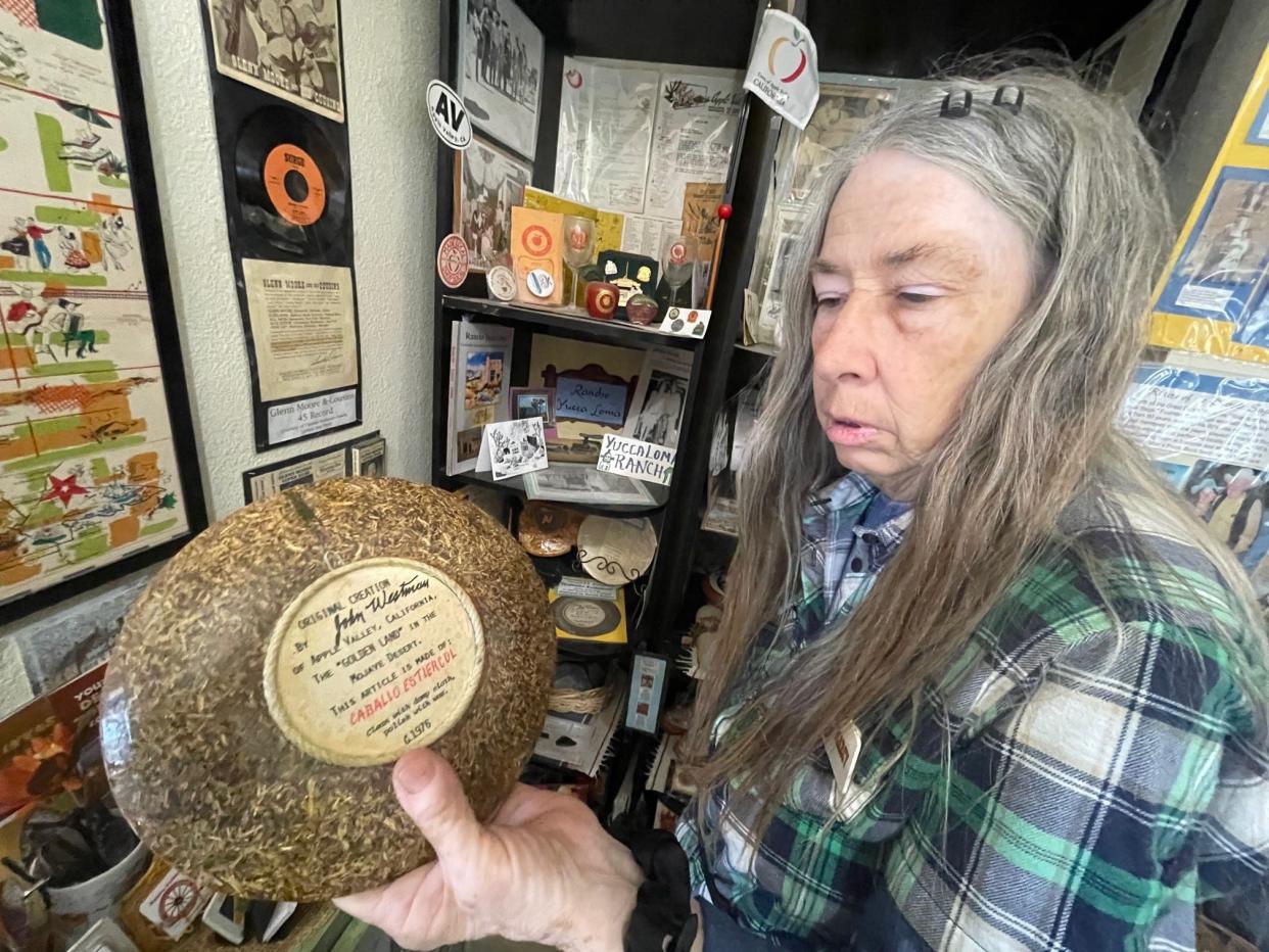 Apple Valley Legacy Museum Director Marcy Taylor holds an ashtray made from horse manure and crafted by John Westman of Apple Valley in 1976.