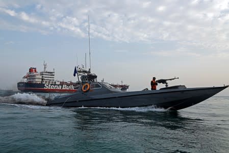 A boat of the Iranian Revolutionary Guard sails next to Stena Impero at Bandar Abbas port