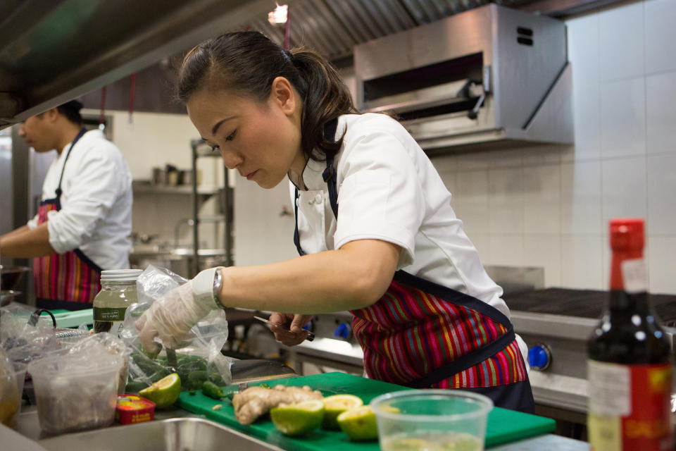 Shirley Chung looks intently at her work as she prepares a dish on the set of 