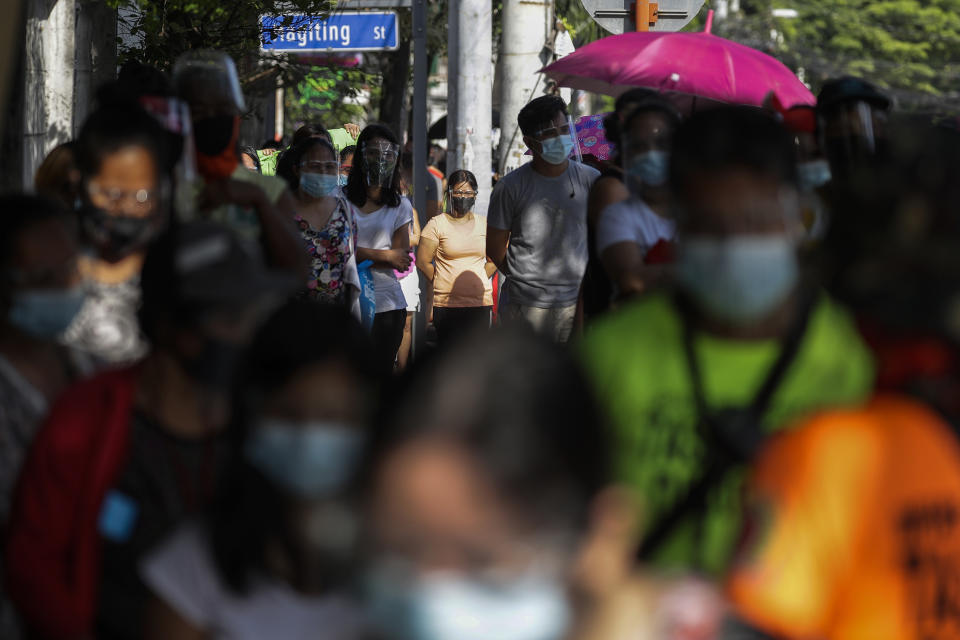 FILE - In this April 19, 2021, file photo, residents wearing face mask and face shield queue to get free food at a makeshift stall called "Community Pantry" at Maginhawa street in Quezon city, Philippines. Developing Asian economies will grow at a solid 7.3% pace this year after contracting slightly in 2020 due to the pandemic, the Asian Development Bank says in its latest regional outlook. (AP Photo/Aaron Favila, File)