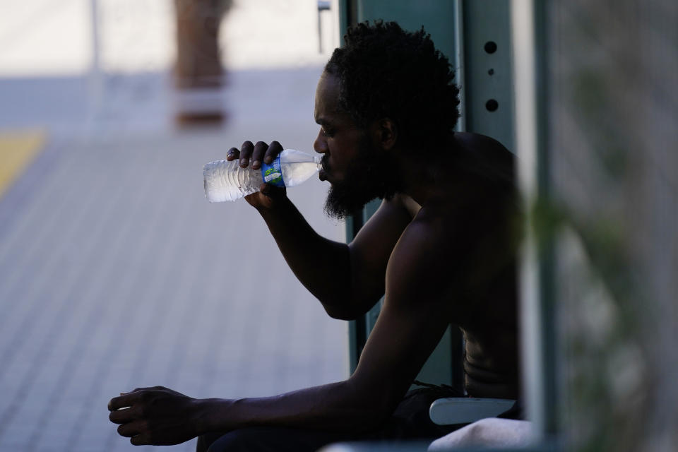 FILE - A person drinks a bottle of water in the shade as temperatures are expected to hit 119-degrees (48.3 Celsius) July 20, 2023, in Phoenix. European climate monitoring organization made it official: July 2023 was Earth's hottest month on record by a wide margin. (AP Photo/Ross D. Franklin, File)