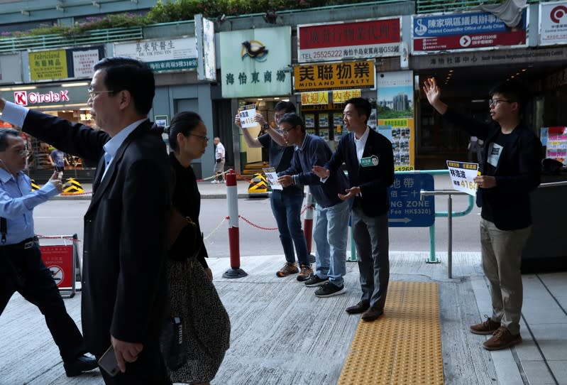 Winning candidate Kelvin Lam and activist Joshua Wong greet people outside South Horizons Station, in Hong Kong