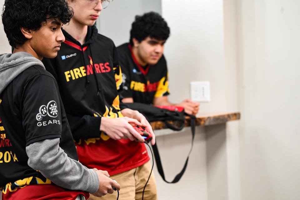 Wasi Rasul, left, and Calum Jessop, right, navigate their robot to score as Raafe Rahman watches at FireWires' headquarters in Osceola on March 17, 2024.