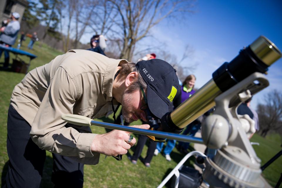 Andrew Mickunas, with the Science Center of Iowa, looks through a telescope pointed to the sun ahead of the solar eclipse Monday, April 8, 2024, at the Drake Municipal Observatory in Des Moines.