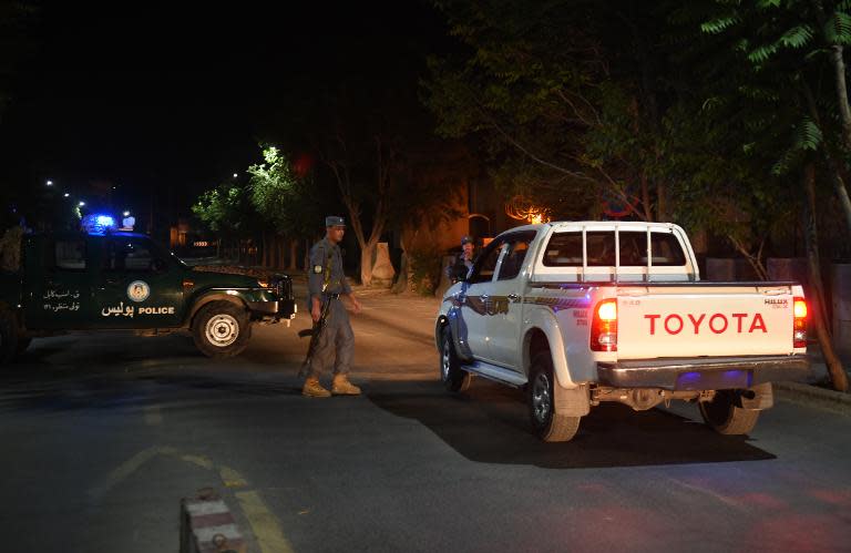 Afghan police officers stand gaurd near the site of an attack in Wazir Akbar Khan in Kabul on May 26, 2015