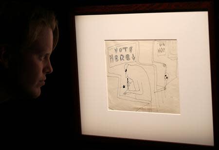 A member of Sotheby's staff looks at an illustration by John Lennon entitled 'Vote Here' at Sotheby's, London March 21, 2014. REUTERS/Paul Hackett