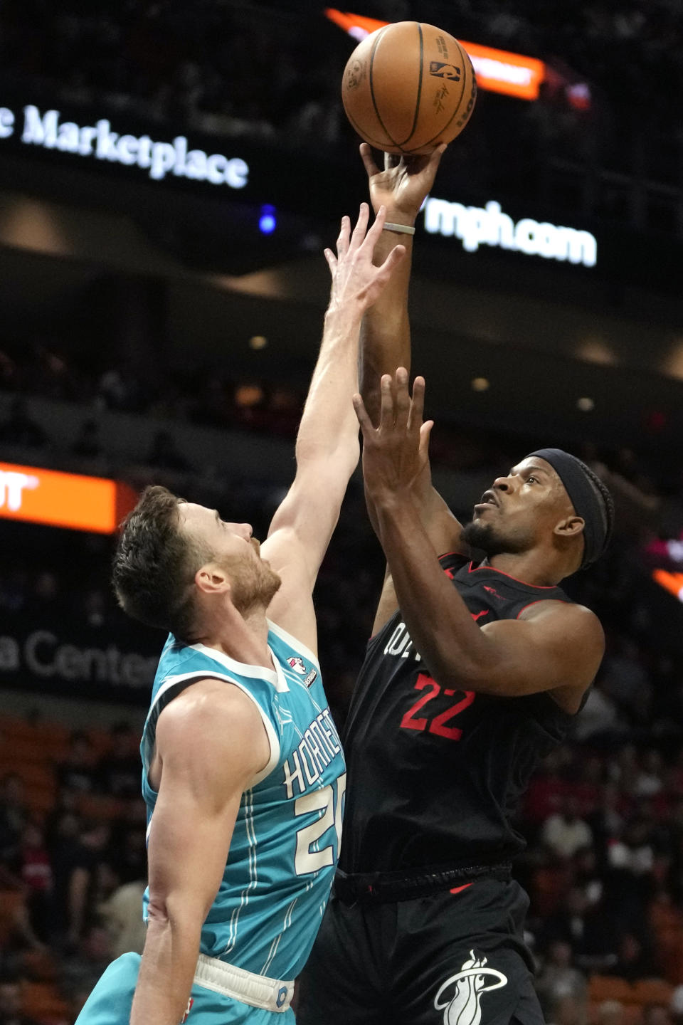 Miami Heat forward Jimmy Butler, right, goes to the basket as Charlotte Hornets forward Gordon Hayward defends during the first half of an NBA basketball game, Wednesday, Dec. 13, 2023, in Miami. (AP Photo/Lynne Sladky)