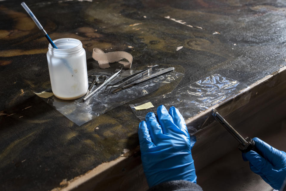 La restauradora Alice Chiodelli trabaja en el estudio de conservación del Palacio Ducal de Venecia, el miércoles 7 de diciembre de 2022. (AP Foto/Domenico Stinellis)