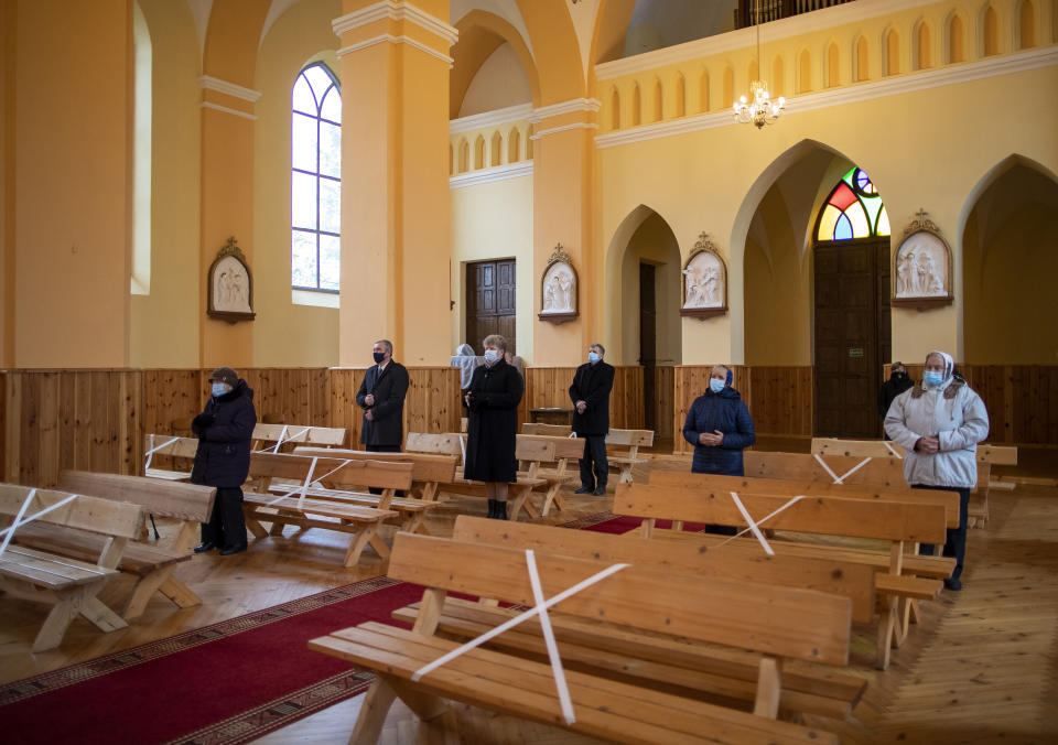 Worshippers wearing face masks and keeping social distance, pray during the Sunday Mass at the Church of Saint Stanislaus bishop in Kazitiskis, some 120km (74,5 miles) north of the capital Vilnius, Lithuania, on Sunday, Nov. 15, 2020. The entire country has been put under a three-week nationwide lockdown from Nov. 7 to Nov, 29, putting restrictions on social life and economic activities in order to stem the spread of the coronavirus, but churches are open for all worship. (AP Photo/Mindaugas Kulbis)