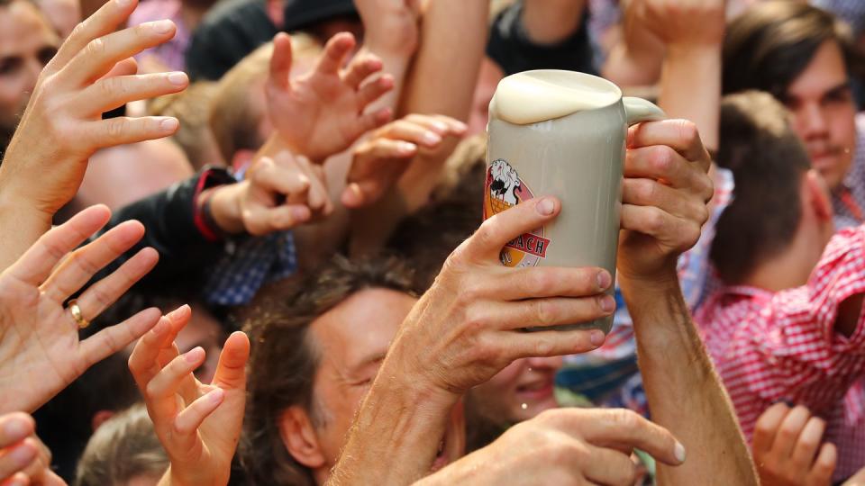 Ob ein Alkohol-Mindestpreis hier hilft? Durstige Besucher der 263. Bergkirchweih in Erlangen greifen beim traditionellen Fassbieranstich nach einer Maß Freibier. Foto: Daniel Karmann