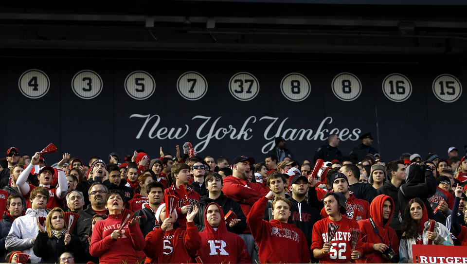 NEW YORK - DECEMBER 30: Fans of the Rutgers Scarlet Knights cheer in front of the wall of retired New York Yankees numbers during the New Era Pinstripe Bowl against the Iowa State Cyclones at Yankee Stadium on December 30, 2011 in the Bronx Borough of New York City. (Photo by Jeff Zelevansky/Getty Images)