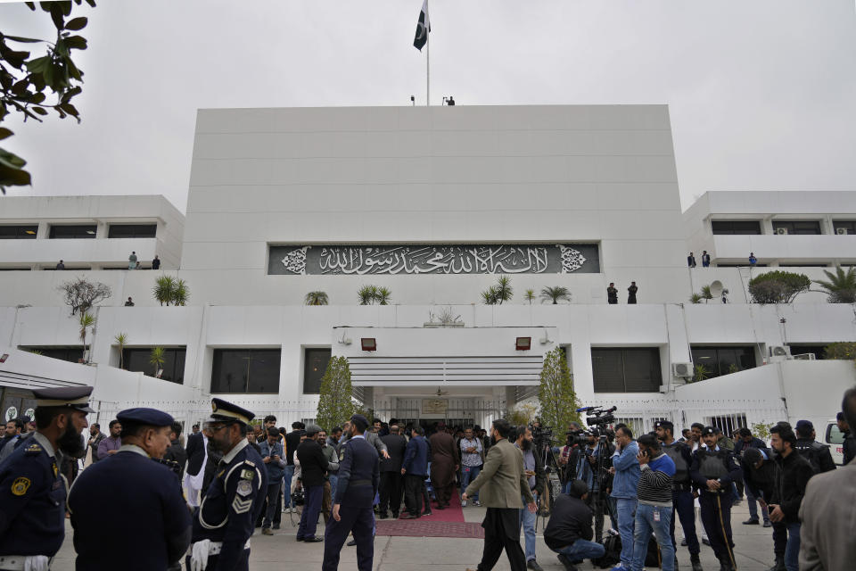 Members of the media and security personnel gather at the main entrance of the National Assembly building, as the opening session of parliament commences, in Islamabad, Pakistan, Thursday, Feb. 29, 2024. Pakistan's National Assembly swore in newly elected members on Thursday in a chaotic scene, as allies of jailed former Premier Khan protested what they claim was a rigged election. (AP Photo/Anjum Naveed)