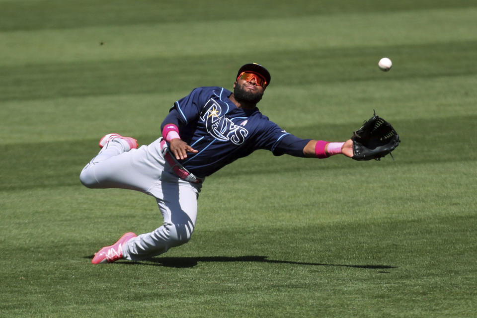 Tampa Bay Rays' Manuel Margot dives for a triple hit by Oakland Athletics' Elvis Andrus during the seventh inning of a baseball game in Oakland, Calif., Sunday, May 9, 2021. (AP Photo/Jed Jacobsohn)