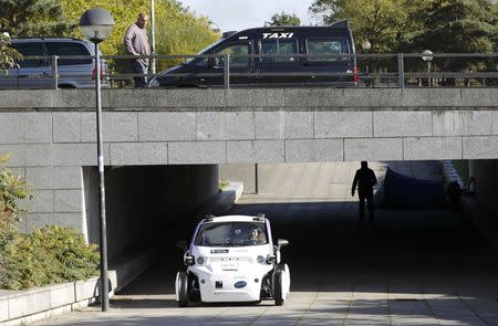 A taxi driver watches as a driverless pod is tested in Milton Keynes, Britain, October 11, 2016. REUTERS/Darren Staples