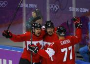 Canada's Drew Doughty (C) celebrates his game-winning overtime goal with teammates John Tavares (L) and Jeff Carter (R) on Finland's goalie Tuukka Rask (not shown) in their men's preliminary round ice hockey game at the 2014 Sochi Winter Olympics, February 16, 2014. REUTERS/Brian Snyder (RUSSIA - Tags: OLYMPICS SPORT ICE HOCKEY TPX IMAGES OF THE DAY)