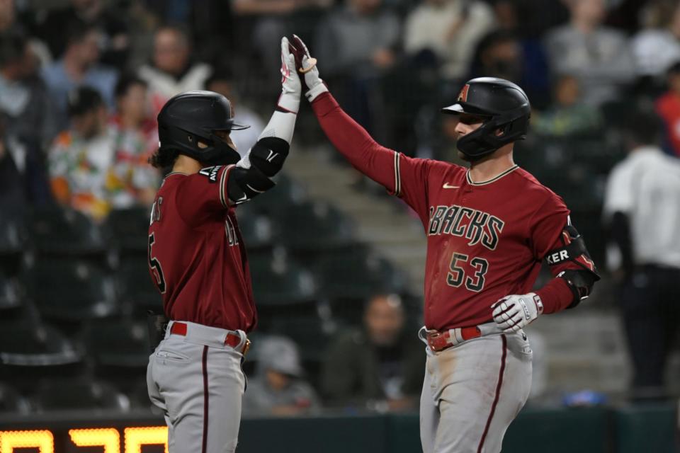Arizona Diamondbacks' Christian Walker (53) celebrates with teammate Alek Thomas at home plate after hitting a two-run home run during the sixth inning of a baseball game against the Chicago White Sox, Tuesday, Sept. 26, 2023, in Chicago. (AP Photo/Paul Beaty)