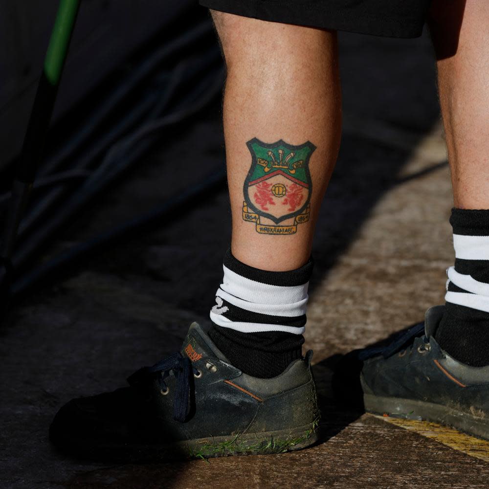A Wrexham groundsman with a club crest tattooed on his leg.