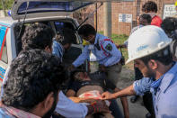 Police personnel and people carry a man (C) that has fainted following a gas leak incident to transport him to a hospital in Visakhapatnam on May 7, 2020. - At least seven people were killed and hundreds hospitalised after a pre-dawn gas leak at a chemical plant in eastern India on May 7 that left unconscious victims lying in the streets, authorities said. The gas escaped out of tanks at a complex owned by South Korea's LG Chem that had suspended operations because of India's coronavirus lockdown. (Photo by STR / AFP) (Photo by STR/AFP via Getty Images)