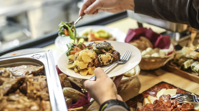 Person filling plate at buffet