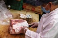 A butcher cuts meat in a supermarket in Manhattan, New York City