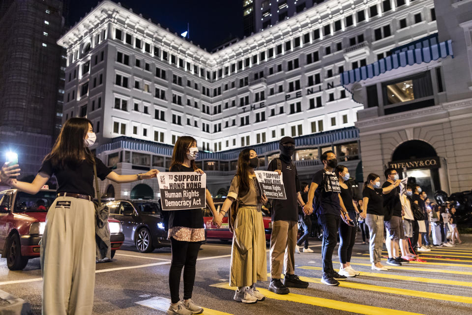 Demonstrators join hands to form a human chain in front of the Peninsula Hotel during the Hong Kong Way event in the Tsim Sha Tsui district of Hong Kong, China, on Friday, Aug. 23, 2019. | Justin Chin/Bloomberg via Getty Images