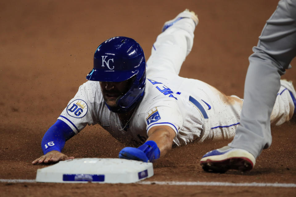 Kansas City Royals Whit Merrifield slides into third base during the sixth inning of a baseball game against the Chicago Cubs at Kauffman Stadium in Kansas City, Mo., Wednesday, Aug. 5, 2020. Merrifield advanced to third on a foul out by teammate Jorge Soler. (AP Photo/Orlin Wagner)