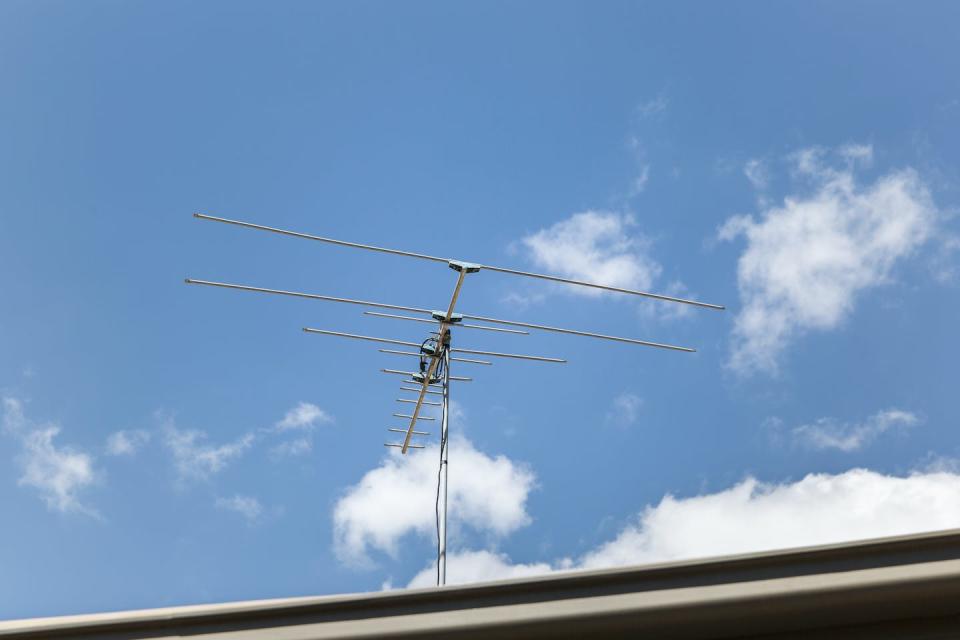 A rooftop antenna receives the TV signal sent by the local television station. <a href="https://www.gettyimages.com/detail/photo/residential-tv-antenna-point-into-beautiful-blue-royalty-free-image/1128664587?adppopup=true" rel="nofollow noopener" target="_blank" data-ylk="slk:Tim Allen/iStock via Getty Images Plus;elm:context_link;itc:0;sec:content-canvas" class="link ">Tim Allen/iStock via Getty Images Plus</a>